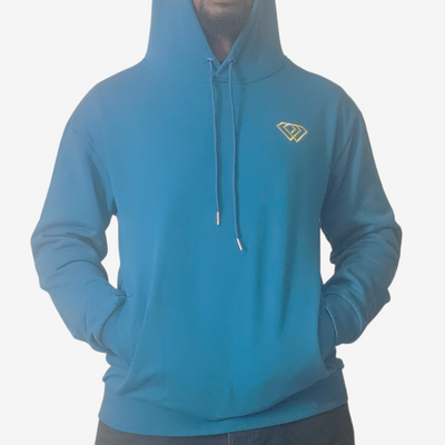 Person wearing a blue hoodie with a small yellow geometric logo on the left chest, hands in front pocket, and hood up, standing against a plain white background