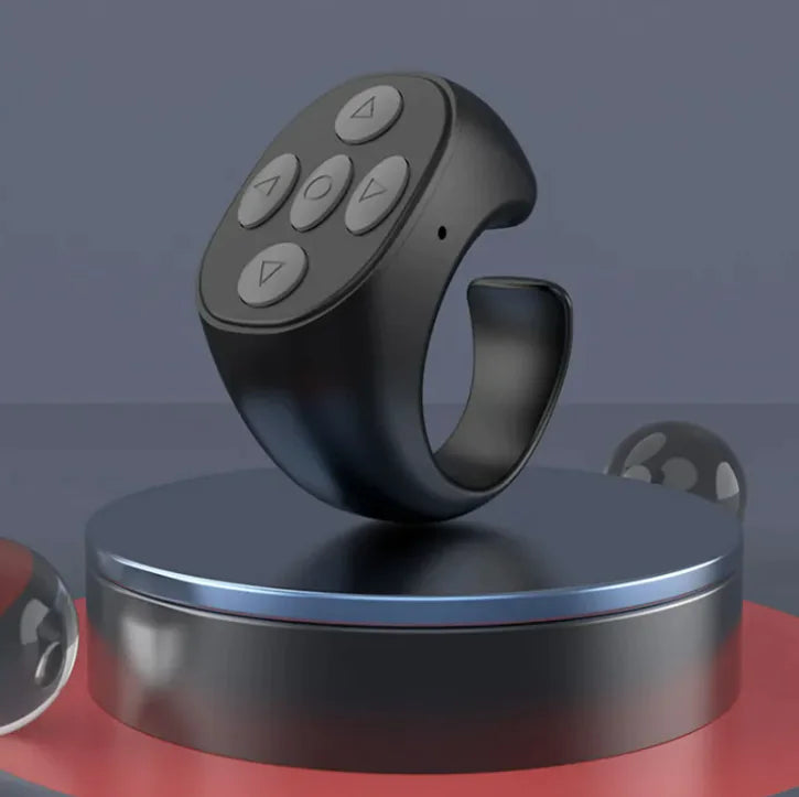 The Jstoremart black silicone ring features a remote control surface with five buttons in a circular pattern. With universal compatibility, it serves as an ideal Bluetooth remote for various devices.